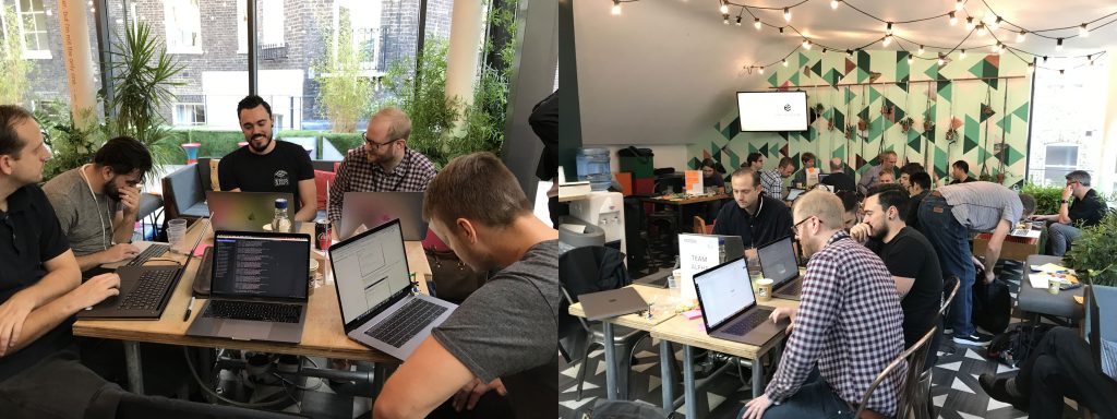 A team of developers with laptops gathered around a table