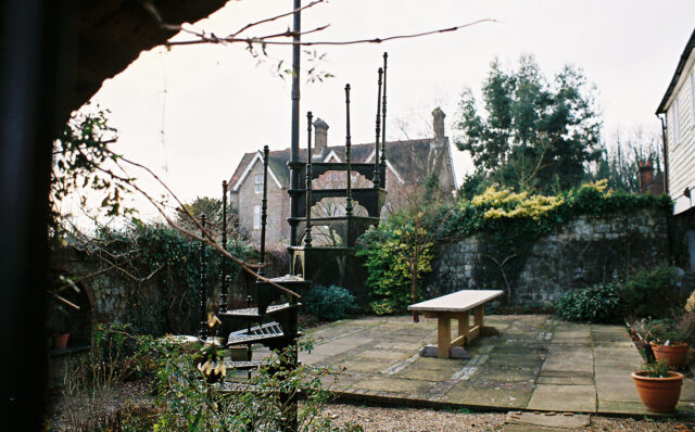 A courtyard containing an outdoor spiral staircase which winds up one storey, but leads nowhere; the top of the staircase is not connected to any structure.