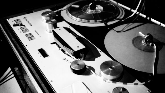 Close up black and white image of a 1/4 inch tape machine