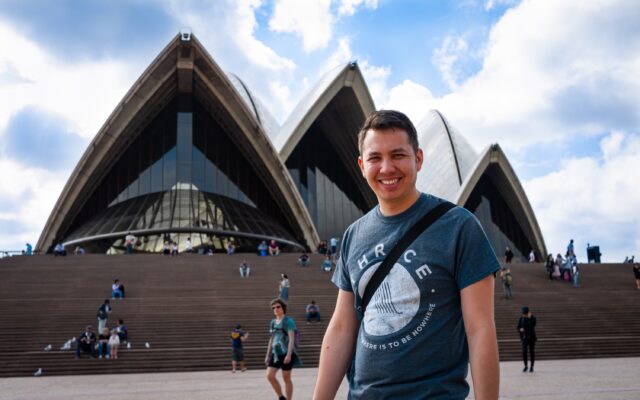 Jerome standing in front of the main frontage of Sydney Opera House