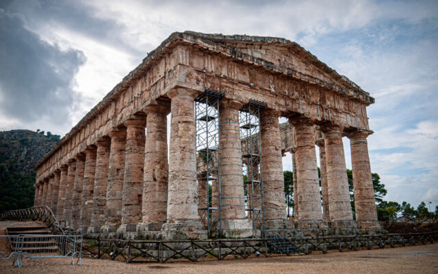 Close up of Segesta Temple taken with a cloudy background. The temple has supporting metal scaffolding between some of the columns.